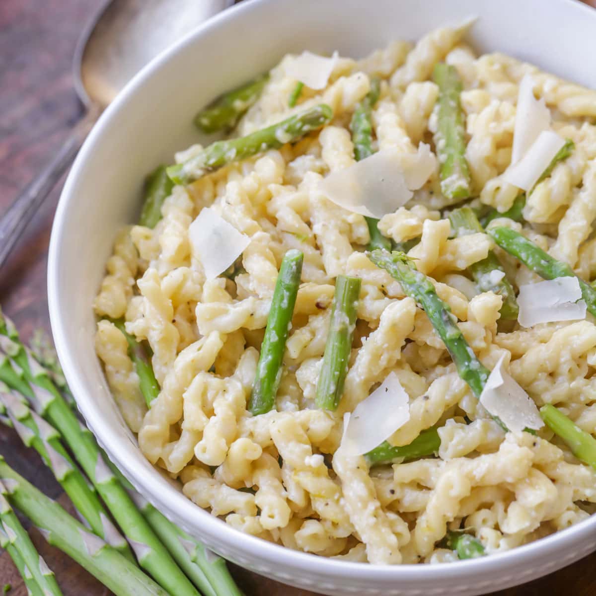 Healthy Pasta Recipes - Lemon Asparagus Pasta in a white bowl topped with parmesan shavings.
