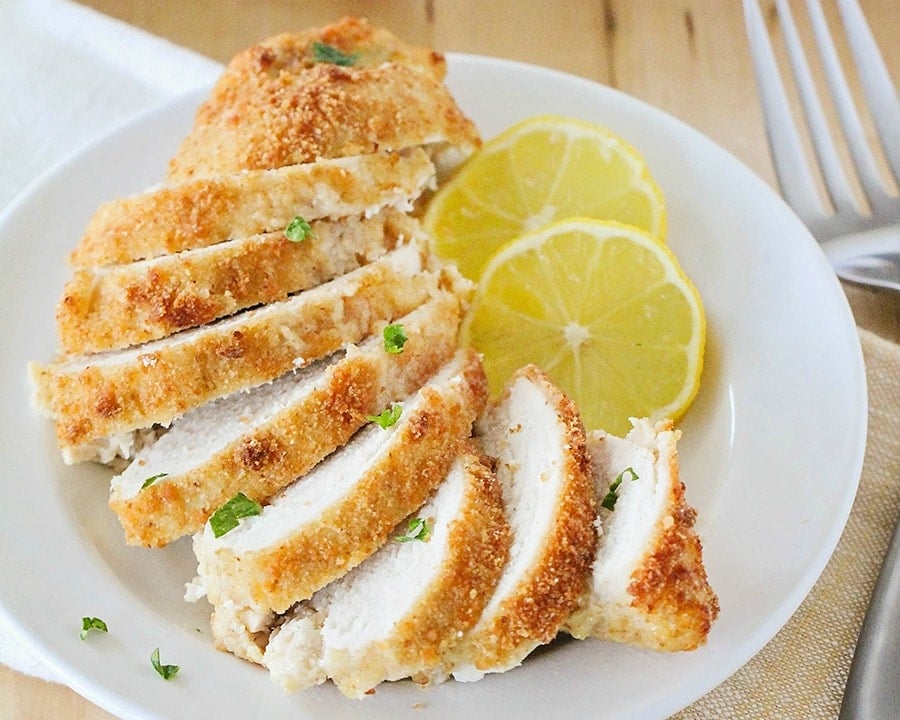 Baked Parmesan Crusted Chicken cut into slices on a white plate.
