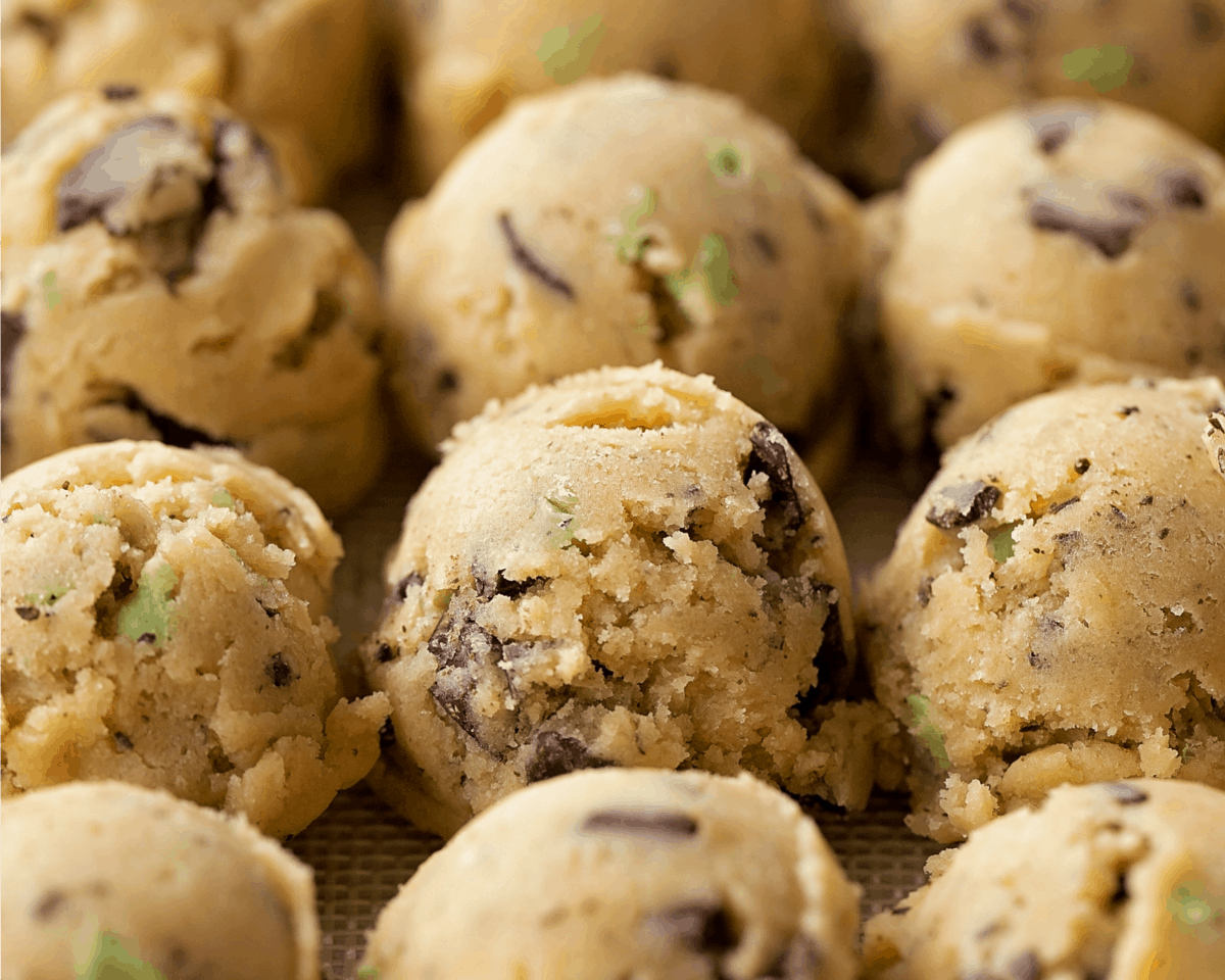 cookie dough balls lined on a baking sheet