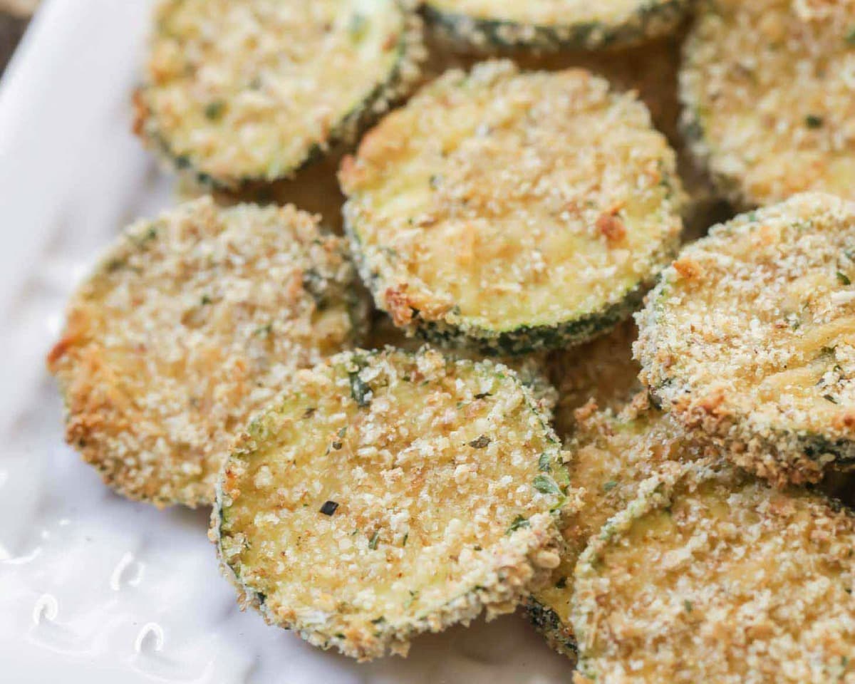 Finger food appetizers - close up of baked zucchini chips piled on a plate.