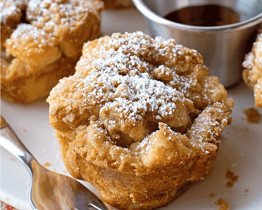 Thanksgiving breakfast ideas - Close up of powder sugar dusted french toast muffins served with syrup.