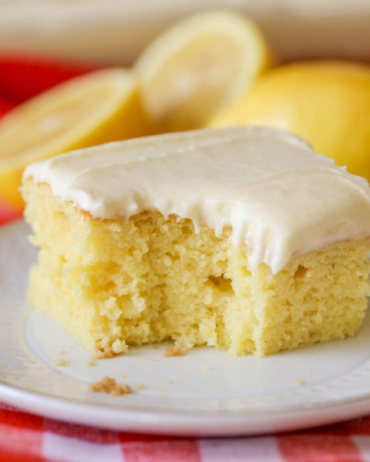 Homemade lemon sheet cake with lemon frosting on a white plate.