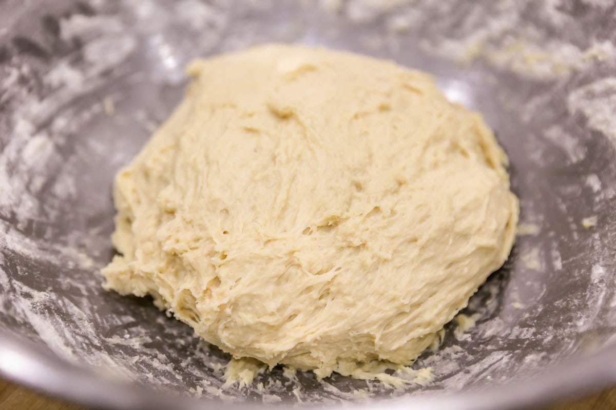 dough for homemade orange rolls in a metal bowl