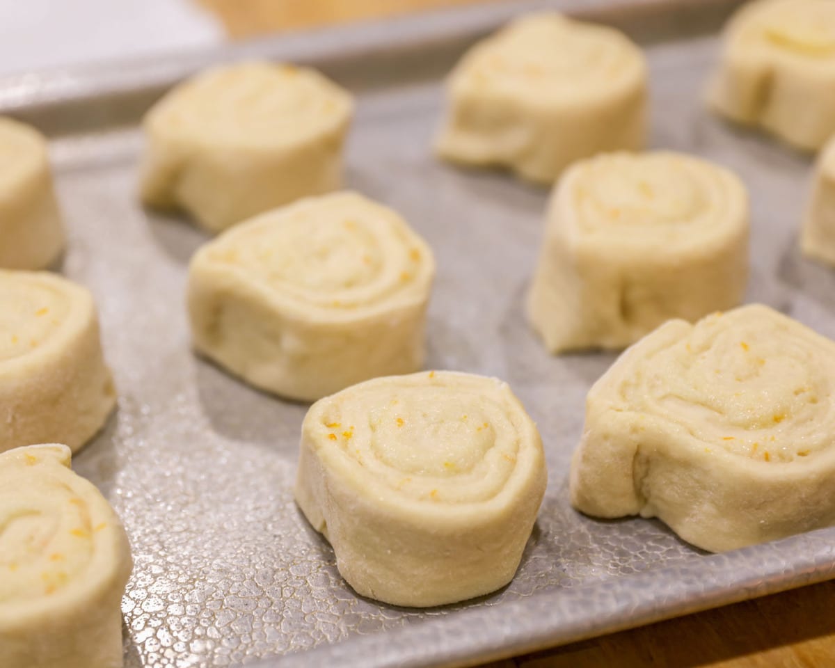 Orange Rolls rising on a sheet pan