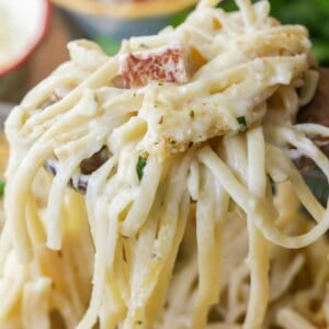 Scooping turkey tetrazzini from a baking dish.