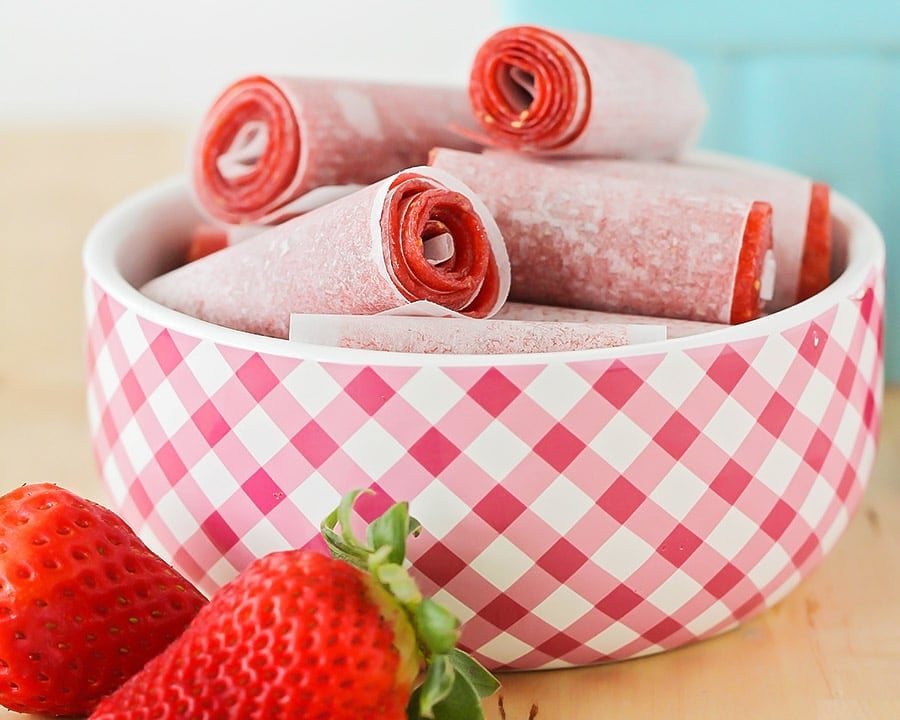 Fruit Leather recipe rolled up in a red and white gingham bowl.
