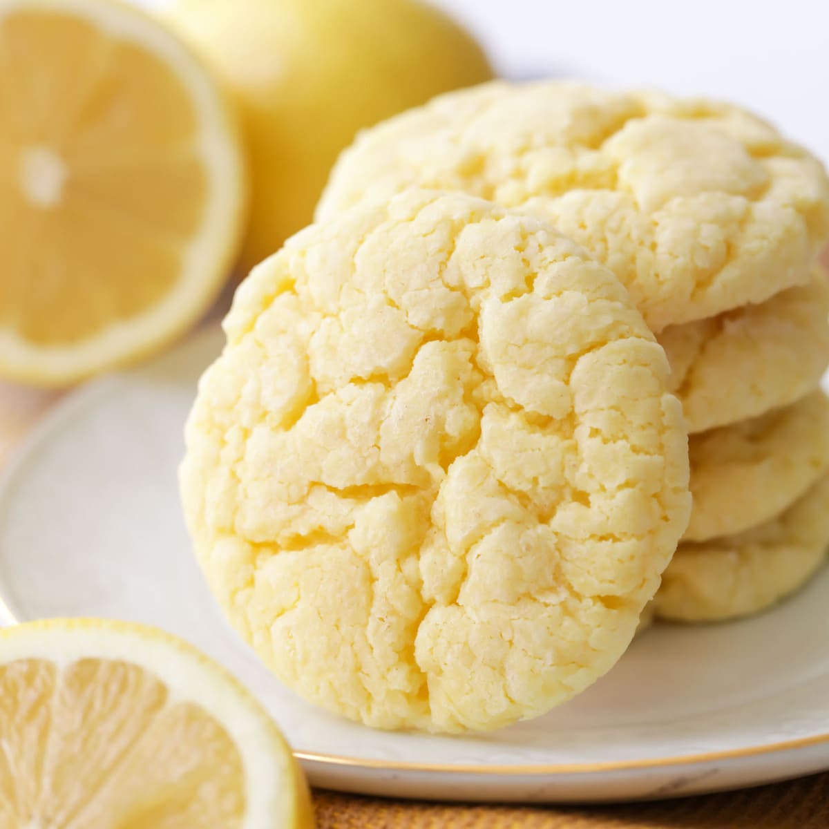 Close up of a pile of lemon cookies on a white plate.