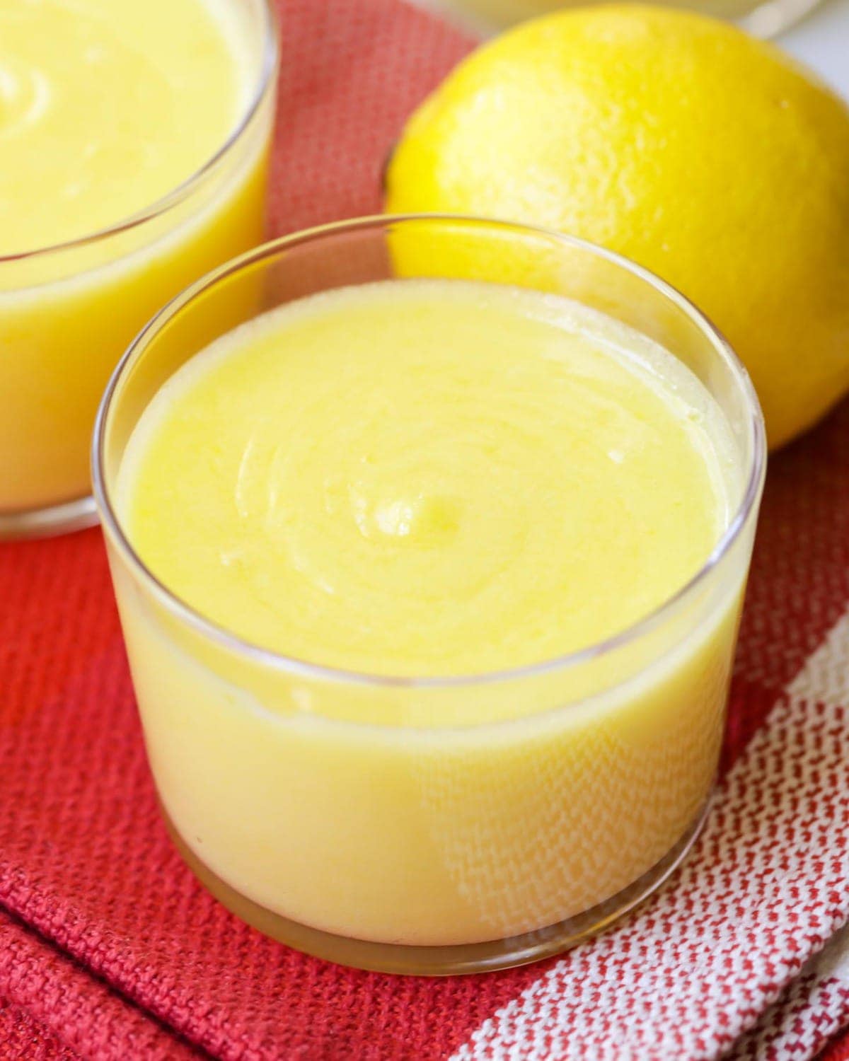 Close up of a glass cup filled with yellow lemon curd