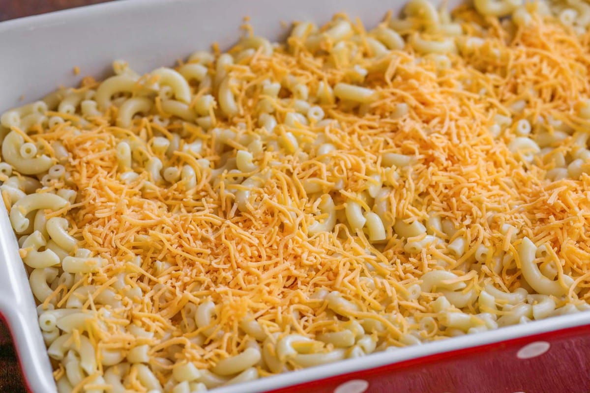 Macaroni topped with shredded cheese in a baking dish.