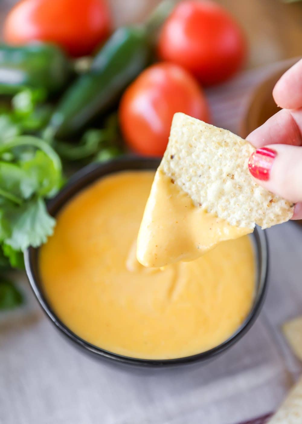 Chip being dipped into nacho cheese dip