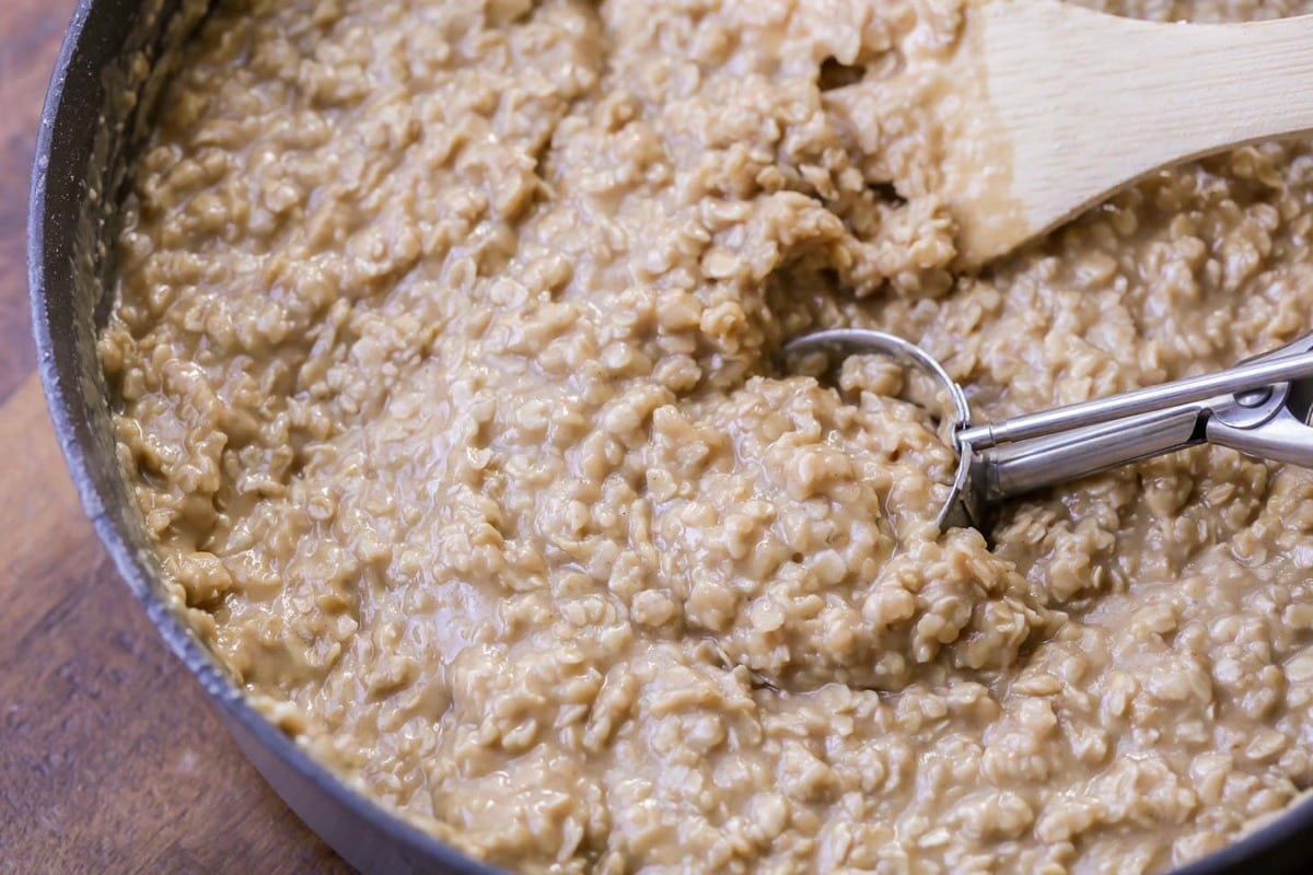 no bake peanut butter oatmeal cookie mixture being scooped with a cookie scoop