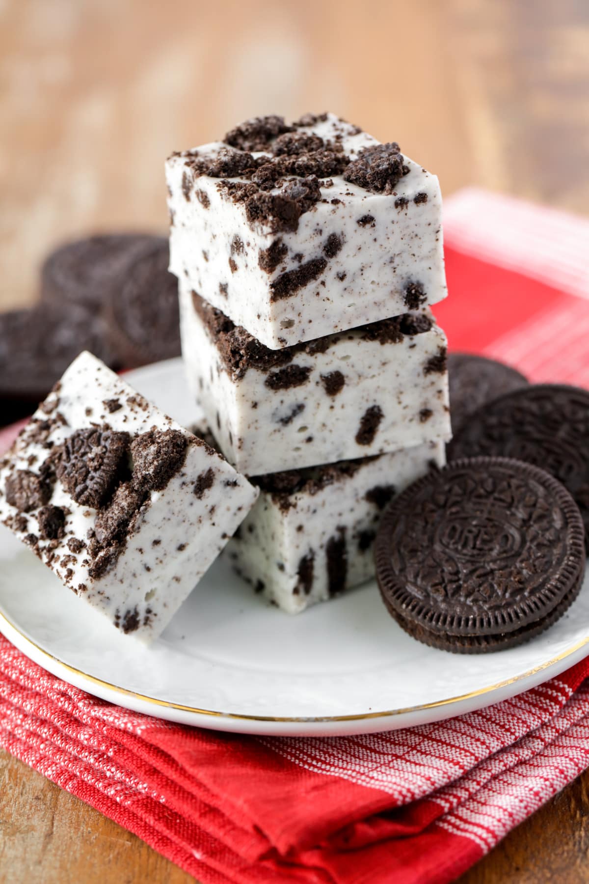 Close up of oreo fudge cut and stacked on a white plate.