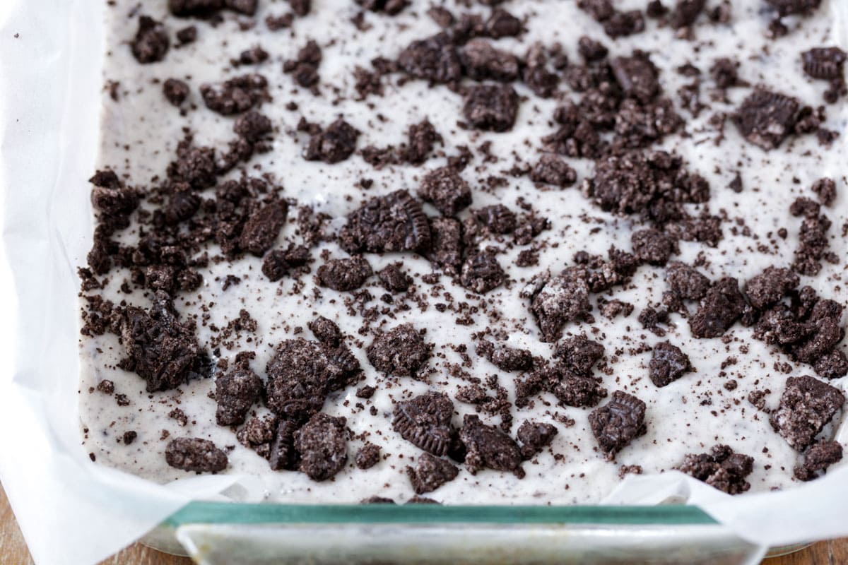 Spreading crushed oreo on top of fudge mixture.