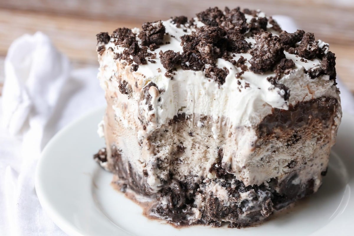 Oreo Ice Cream Cake recipe cut on plate with a bite missing.
