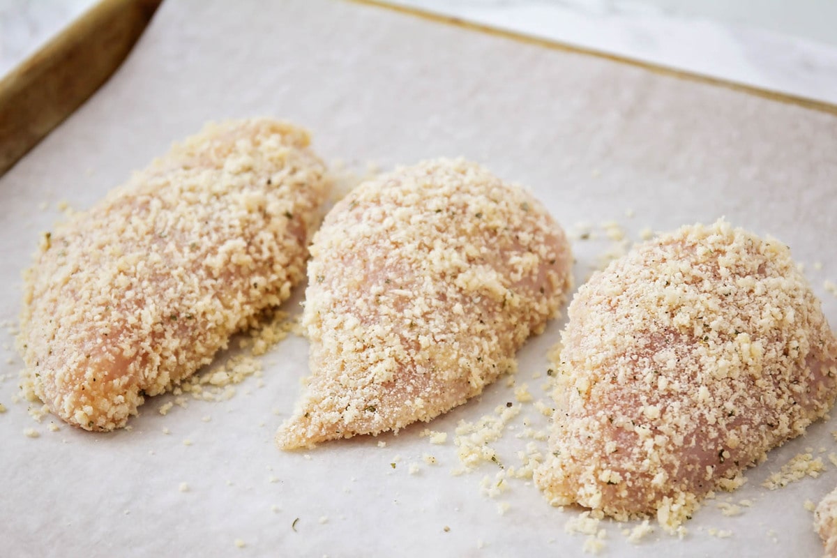 Chicken covered in Parmesan cheese and breadcrumbs.