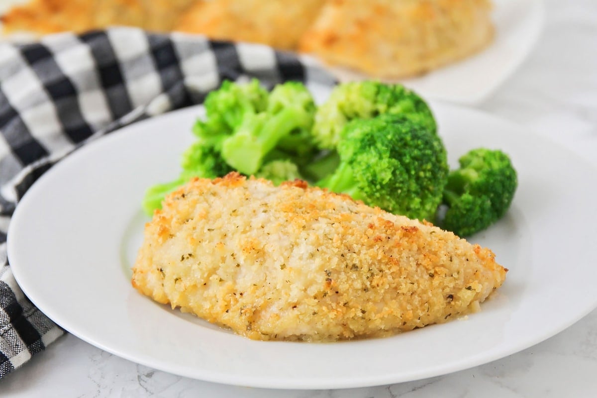 Chicken Breast Recipes - Baked ranch chicken on a white plate with broccoli.