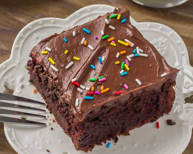 Cakes that feed a crowd - square slice of moist sour cream chocolate cake on a plate.