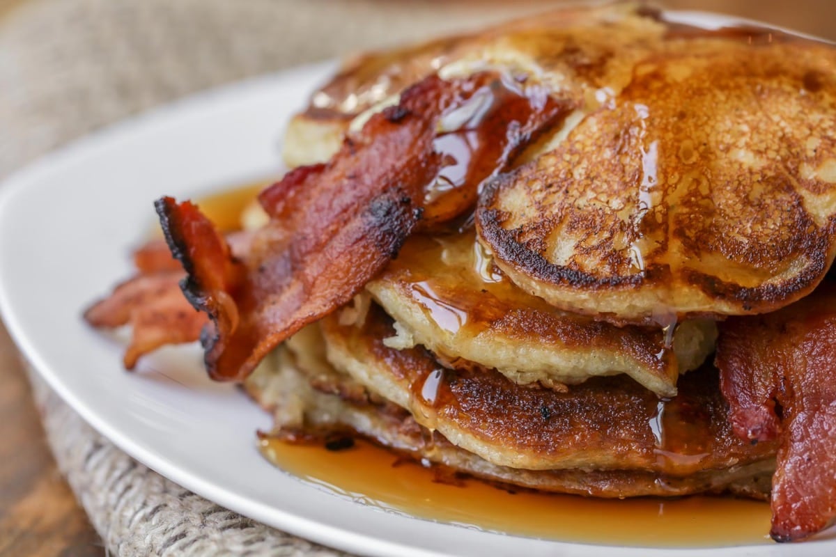 Breakfast for dinner - bacon pancakes topped with syrup and bacon strips.