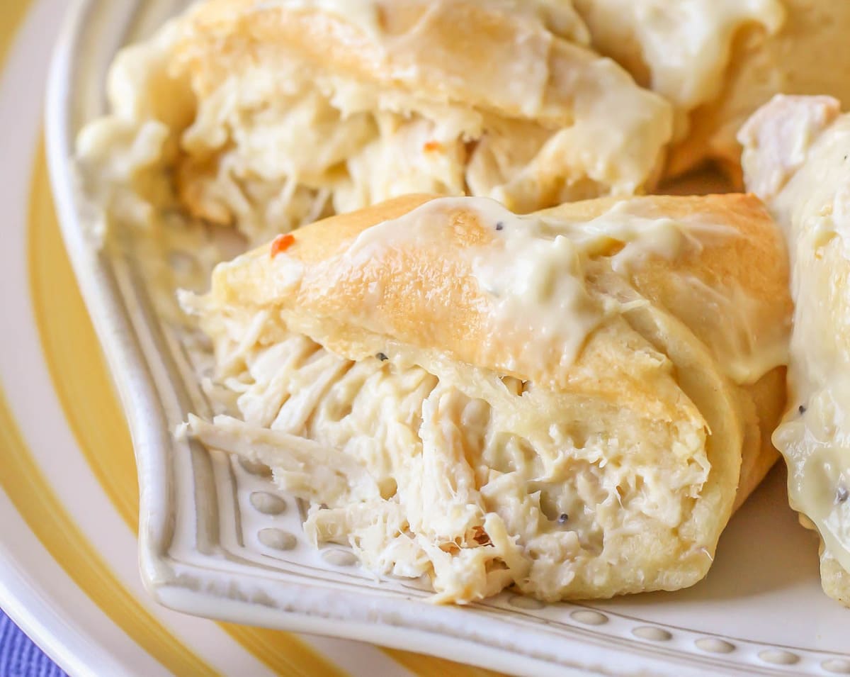 5 Ingredient Recipes - Halved crescent roll chicken bundles on a white plate.
