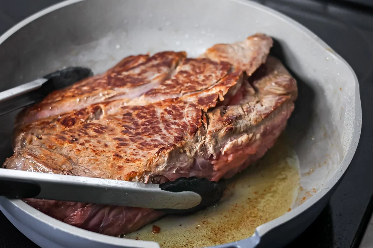 Roast being browned in skillet.