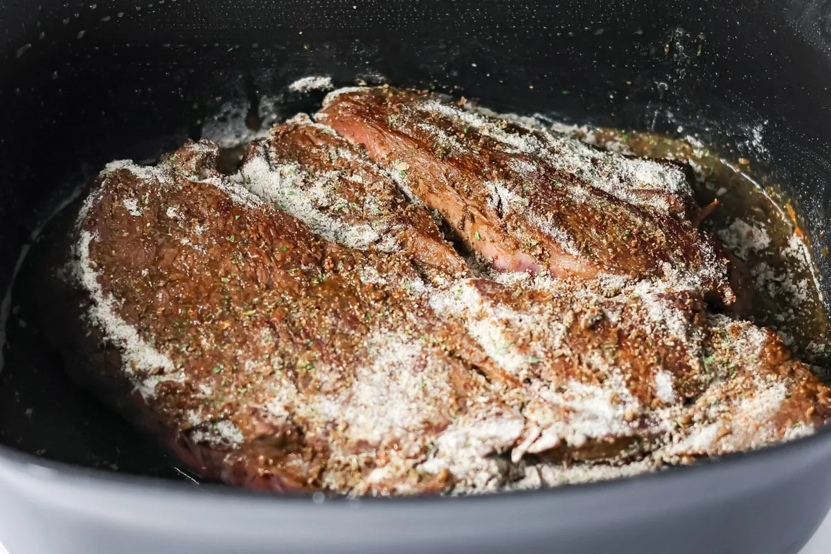 Seasonings poured over pot roast in crock pot.