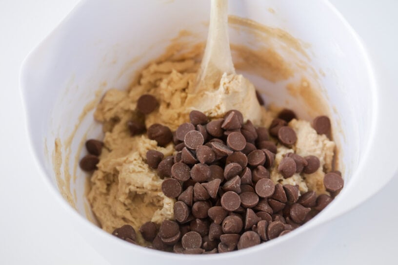 Grab a Spoon! This Eggless Cookie Dough recipe is for all the cookie dough lovers out there! With NO eggs included in this recipe, you can use this edible cookie dough in shakes, fudge, brownies, or eat it all by itself!! Adding chocolate chips to eggless cookie dough recipe.