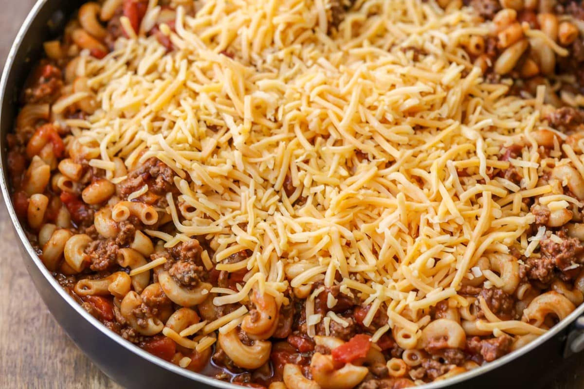 Cheesy Hamburger Goulash in pan topped with shredded cheese.