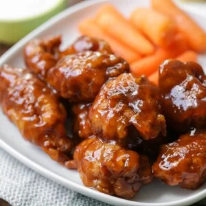 Boneless bbq wings served with carrots and sauce.