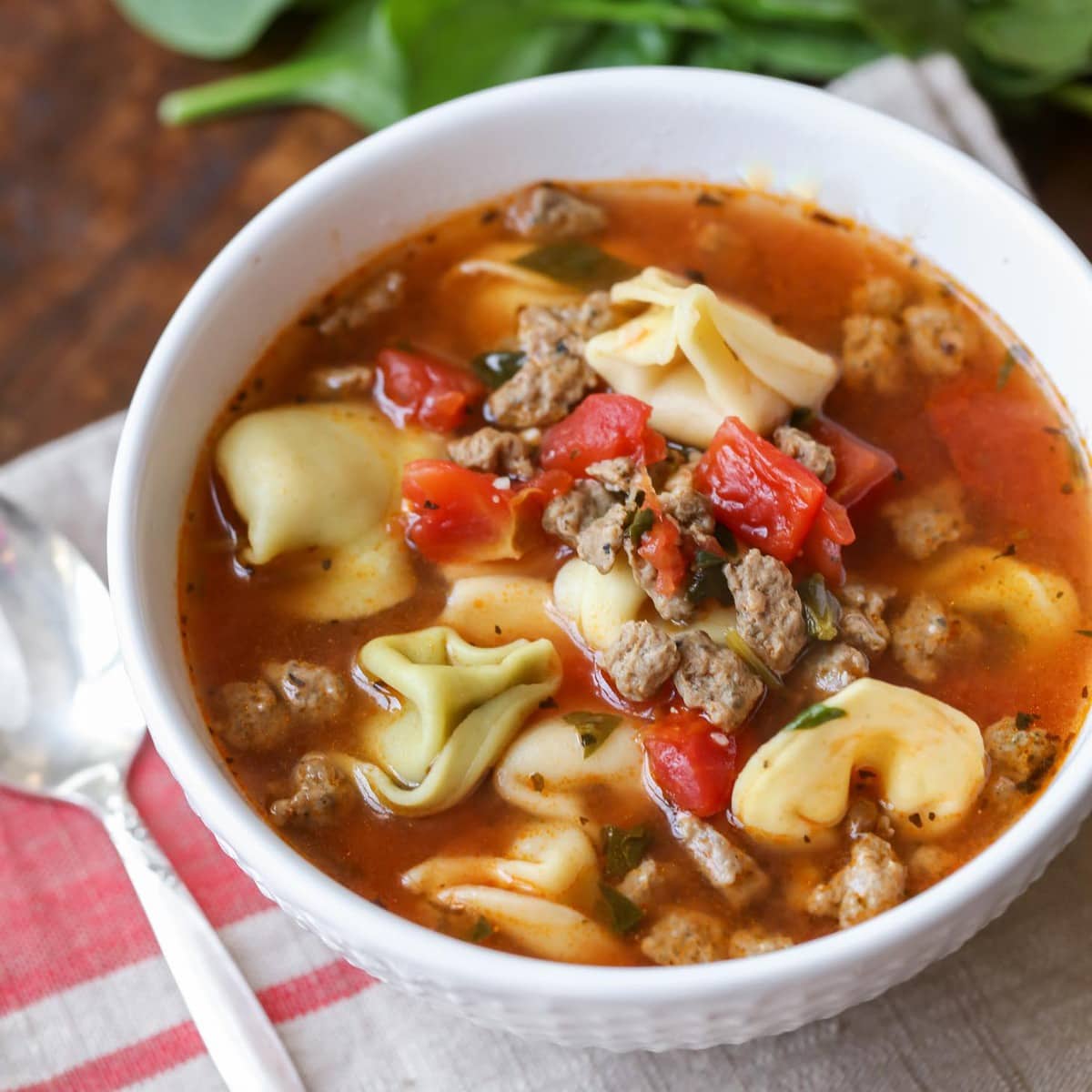 Easy soup recipes - Sausage tortellini soup in a white bowl.