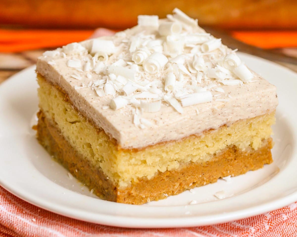 Thanksgiving desserts - a square slice of magic pumpkin cake served on a white plate.