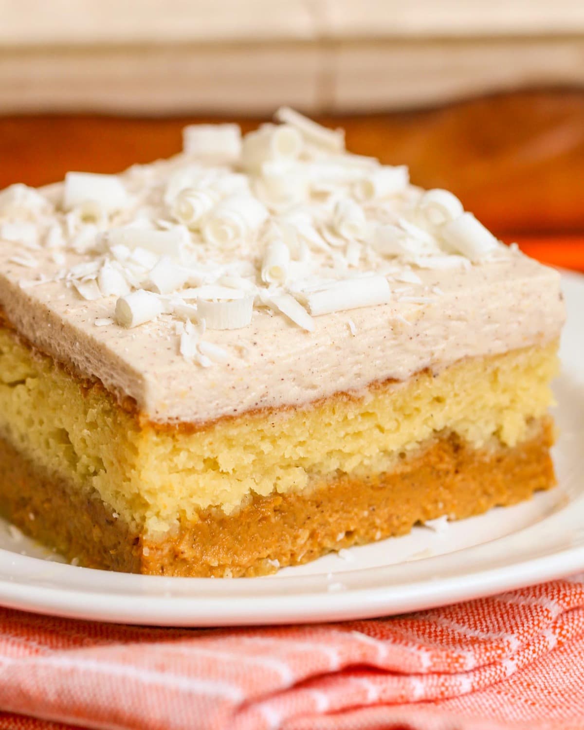 Pumpkin Magic Cake topped with white chocolate curls on a white plate.