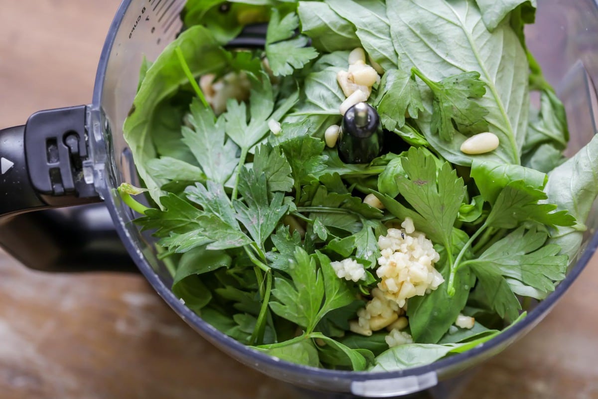 Basil, garlic, and pine nuts in a food processor