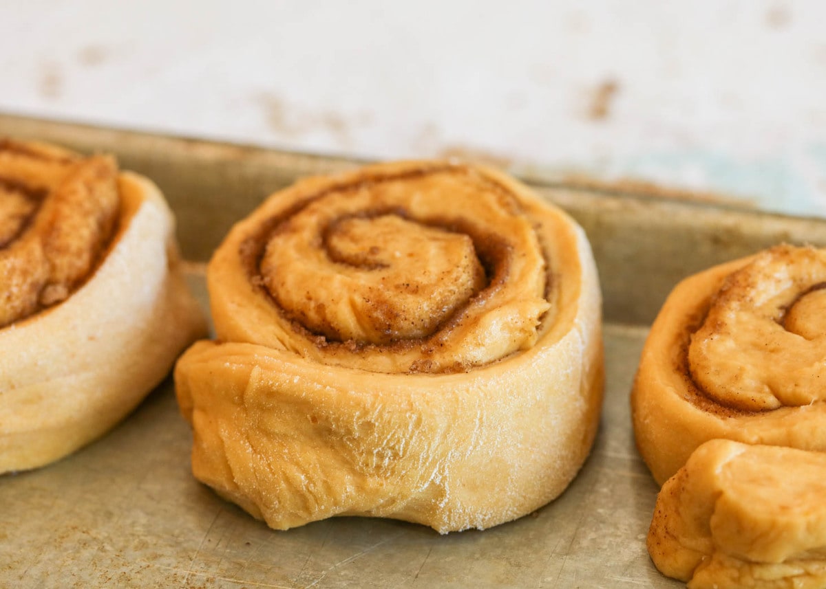 Pumpkin Spice Cinnamon Rolls on a baking sheet.