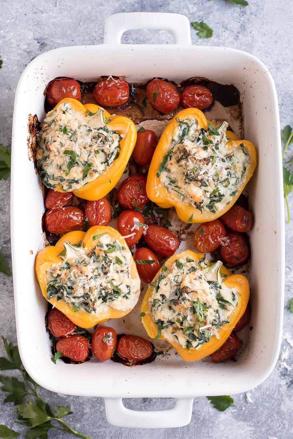 Easy Stuffed Bell Peppers and grape tomatoes in a white baking dish