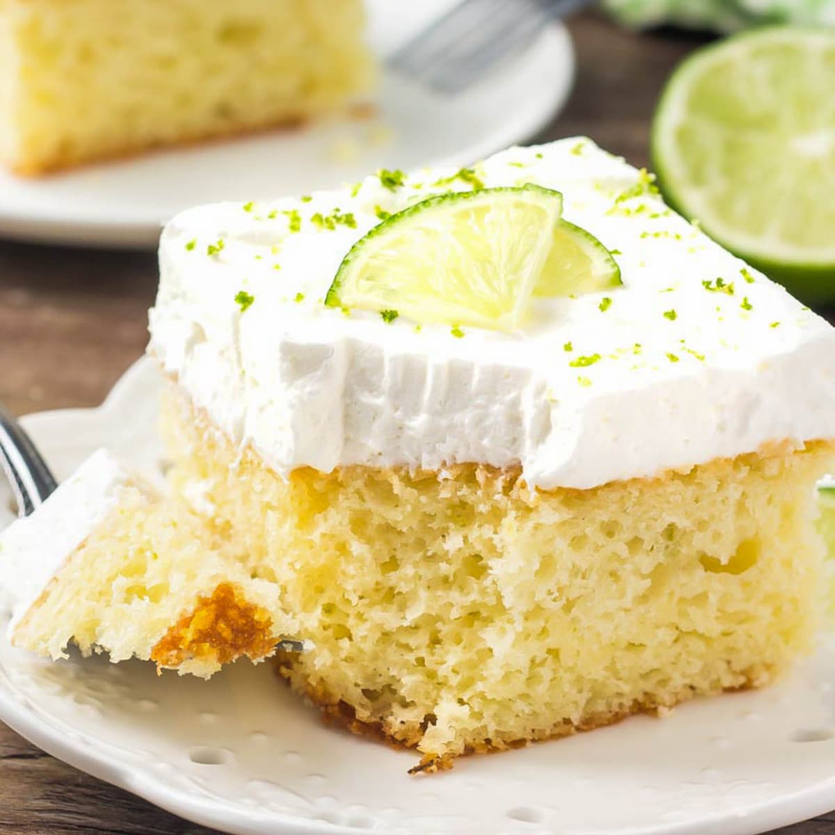 Key Lime Cake with a bite missing served on a white plate.