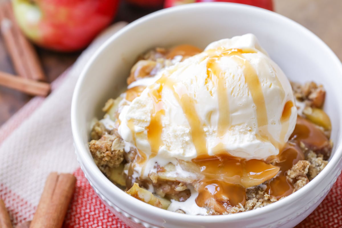Apple Crisp Recipe topped with vanilla ice cream and caramel syrup