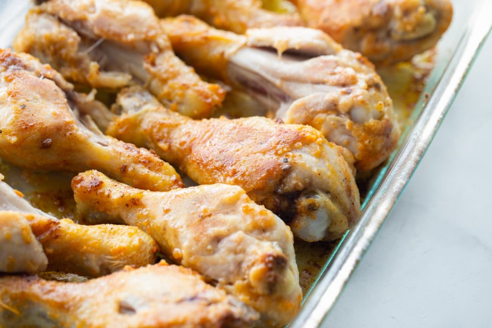 Baked drumsticks in a glass baking dish.