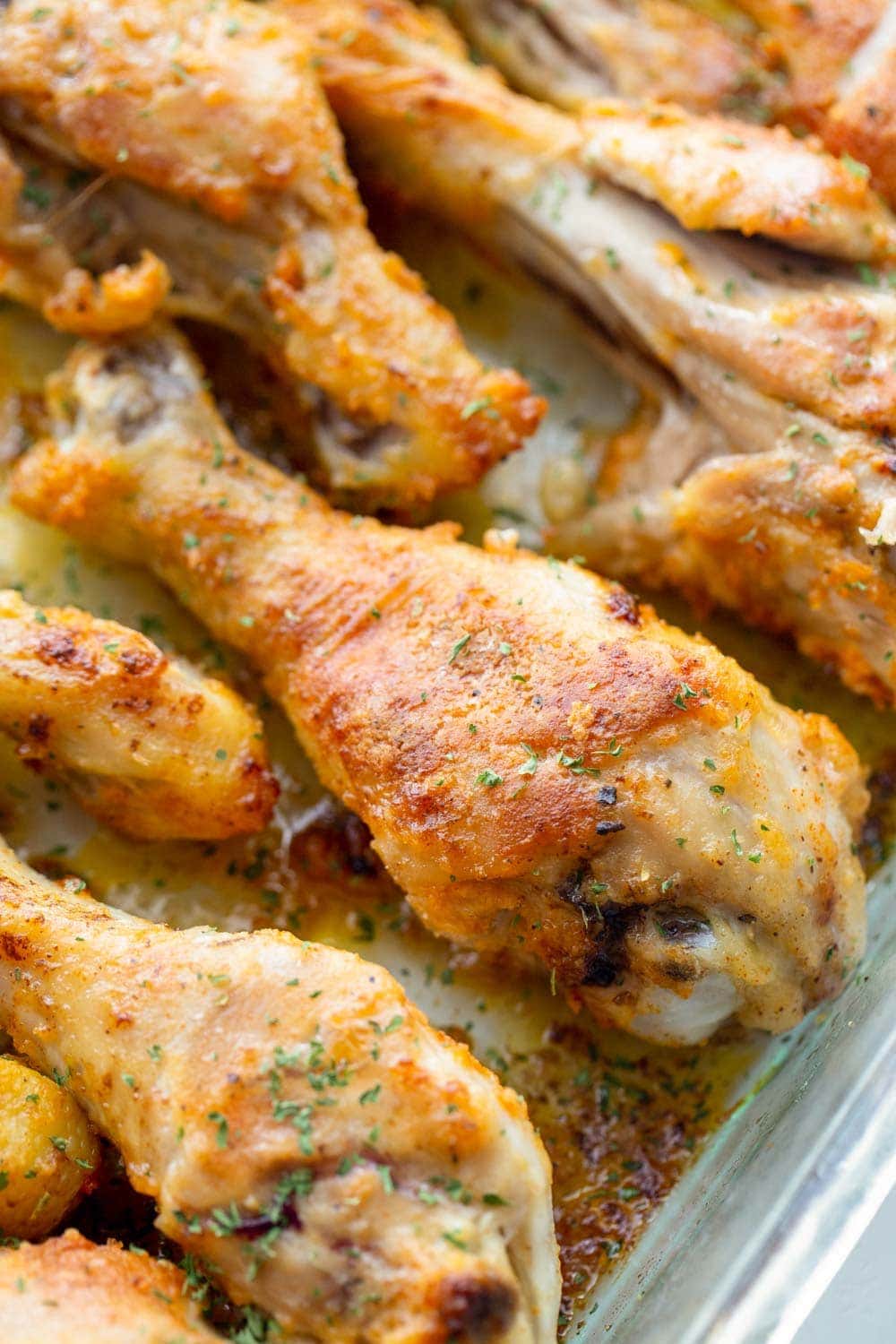 Close up of baked drumsticks in a glass baking dish