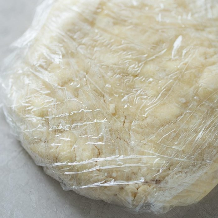 Pie crust wrapped in plastic wrap.