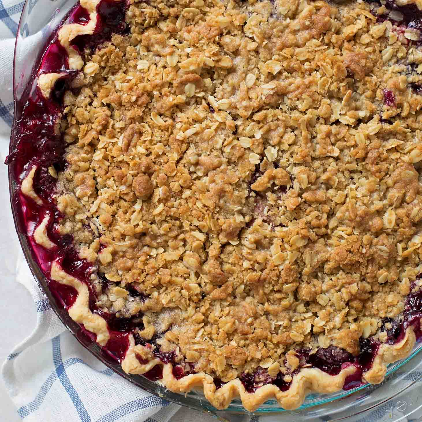 Close up image of triple berry pie in glass dish pan.