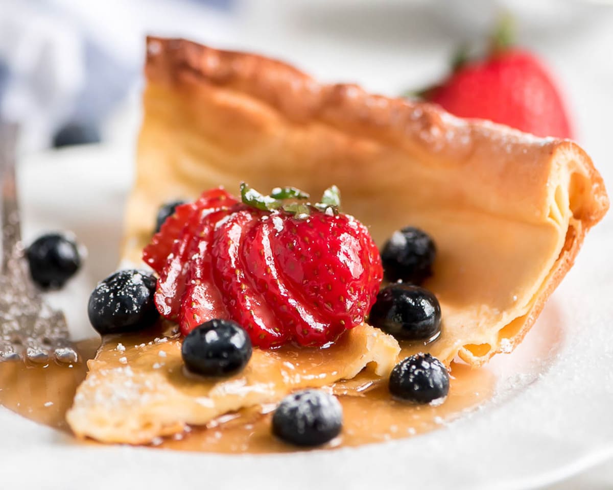 A pancake slice served on a plate with fresh berries.