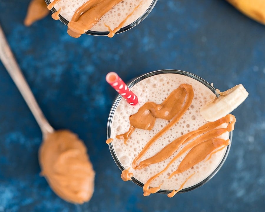 Peanut Butter and Banana Smoothie in a glass with peanut butter drizzle