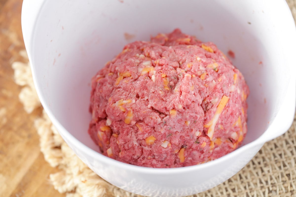 Ingredients for homemade ranch burger patties being combined in a white bowl.