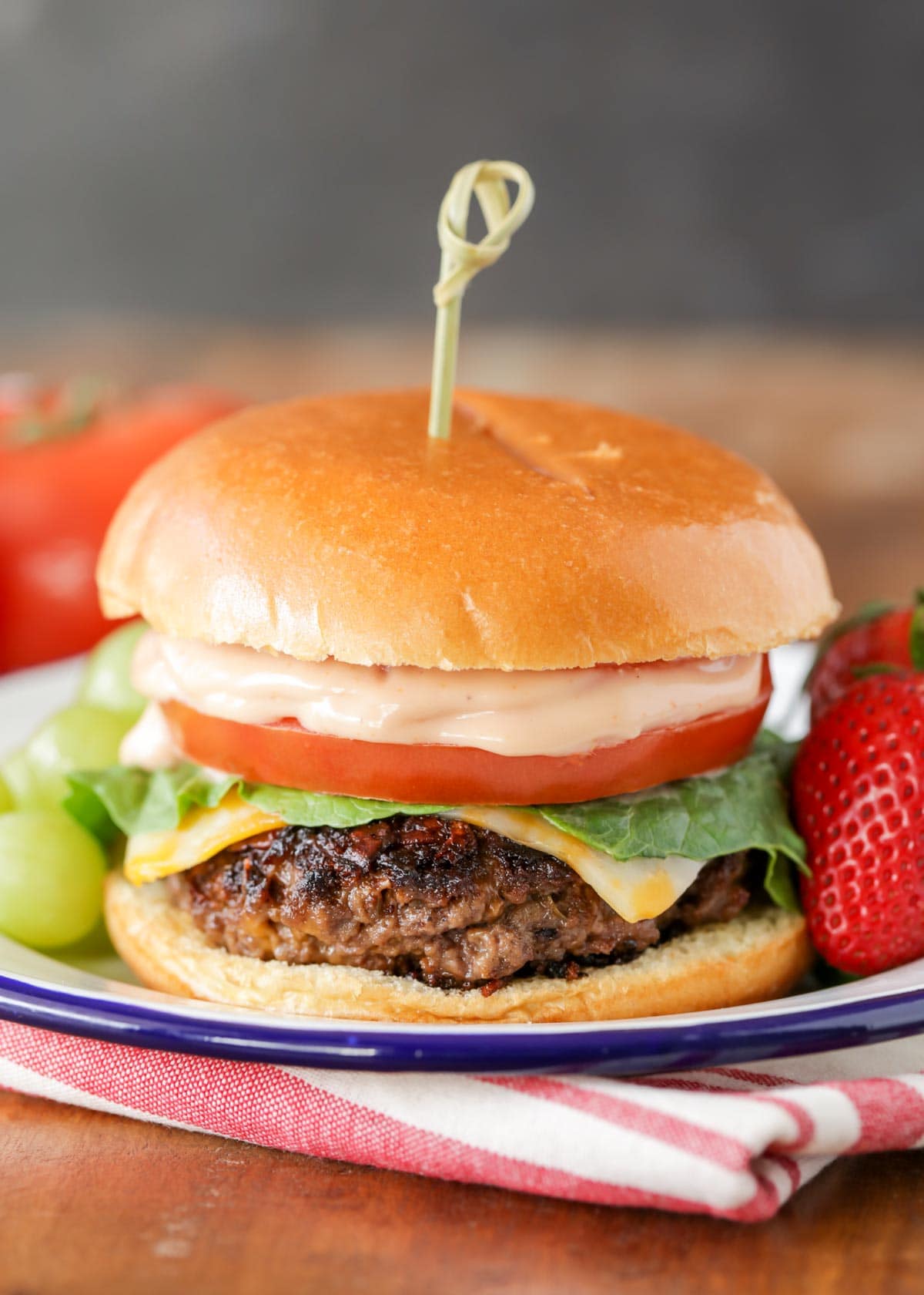 Ranch burger recipe on a plate with a side of fruit.