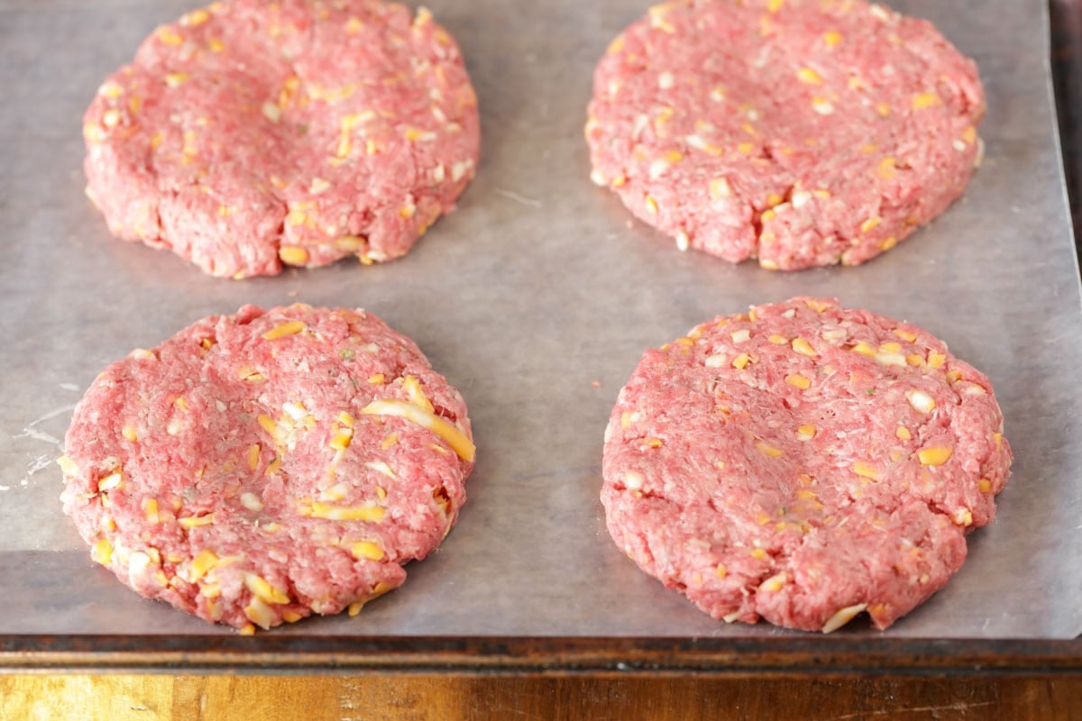 Homemade ranch burger patties on a sheet of wax paper before being cooked.
