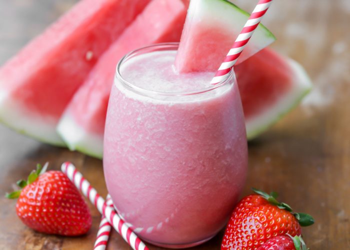 Watermelon breakfast smoothie in a glass with a straw and slice of watermelon