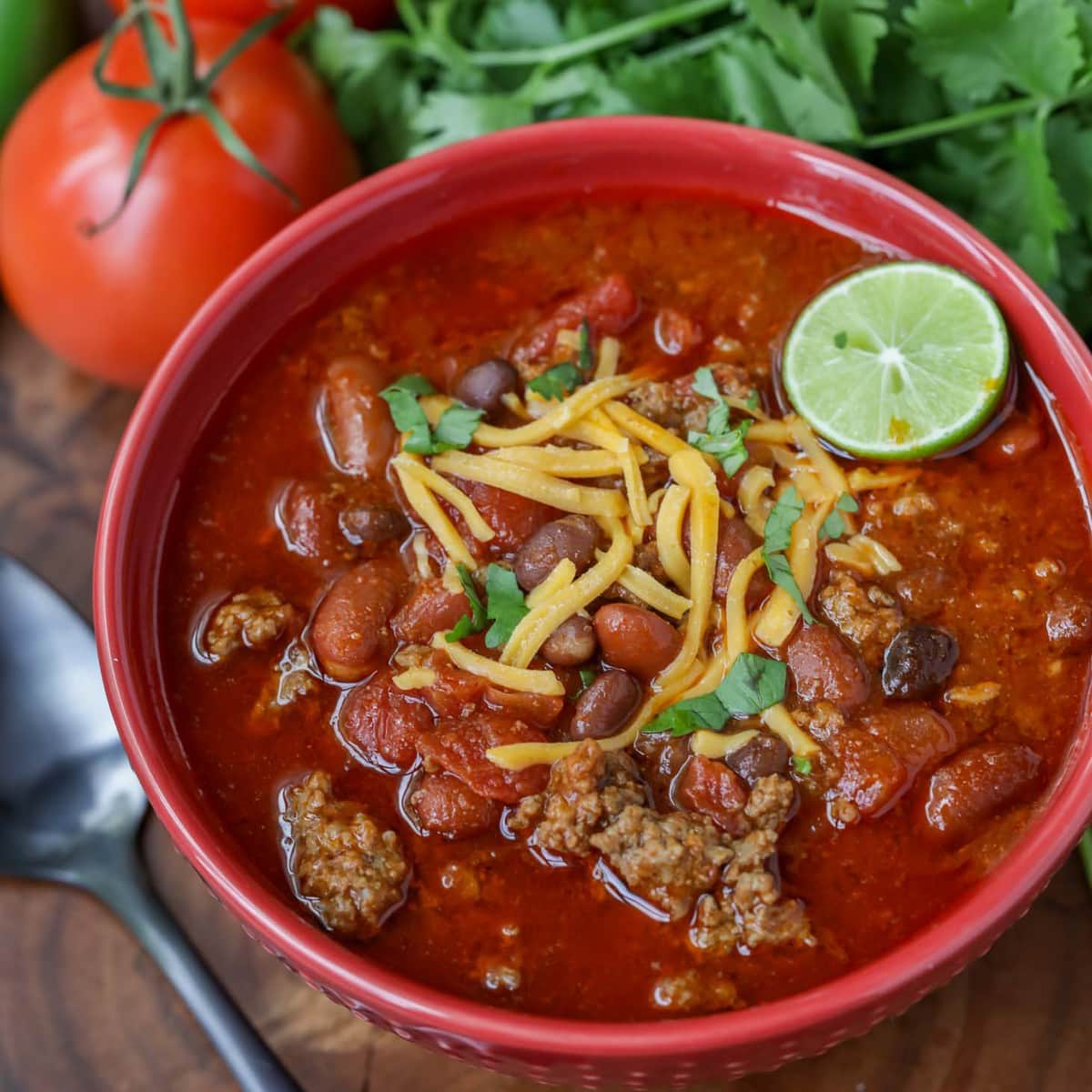 Halloween dinner ideas - a bowl of the best chili recipe garnished with lime and cheese.