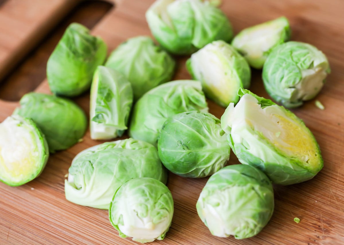 Halved brussel sprouts on cutting board.