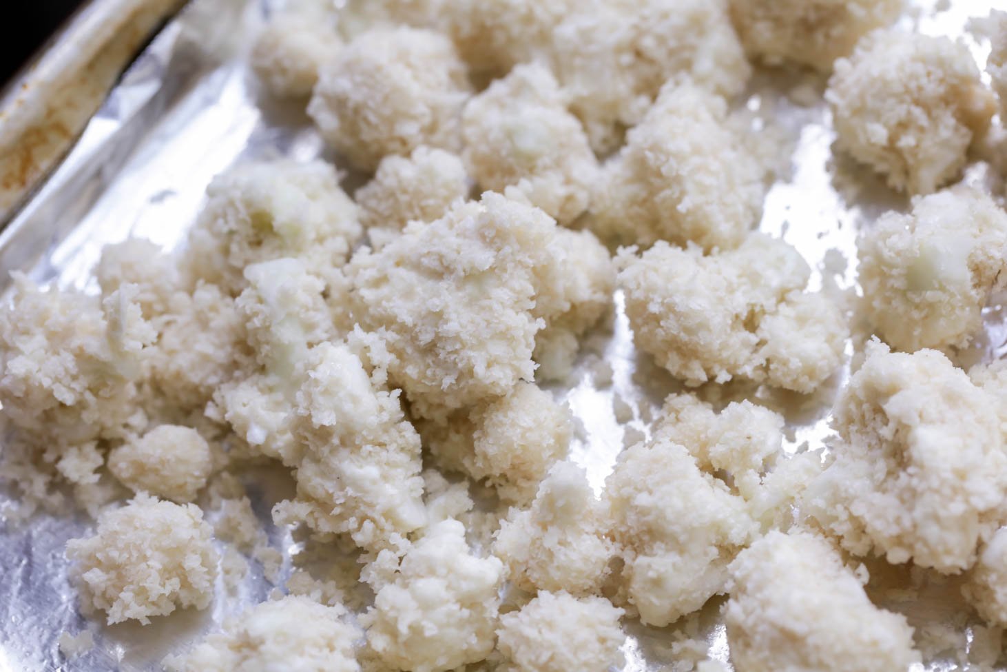 Buffalo Cauliflower Bites tossed in Panko and on baking sheet