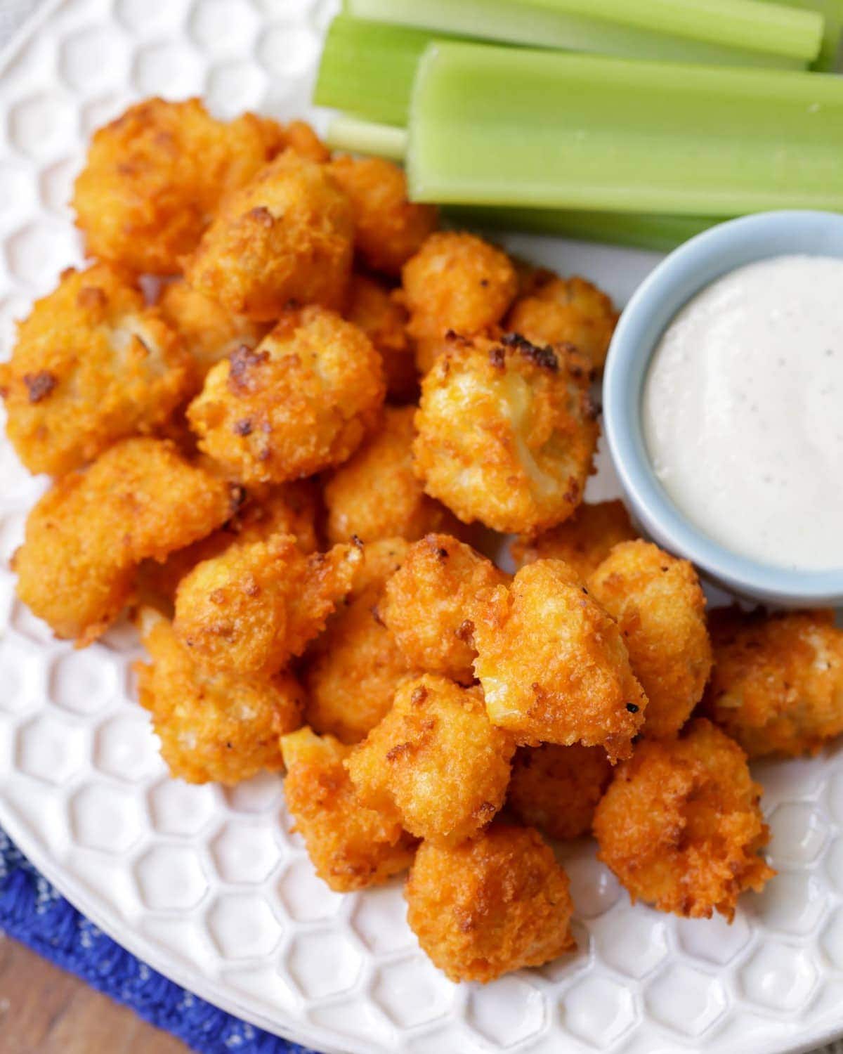 Cauliflower Buffalo Bites close up on plate with celery